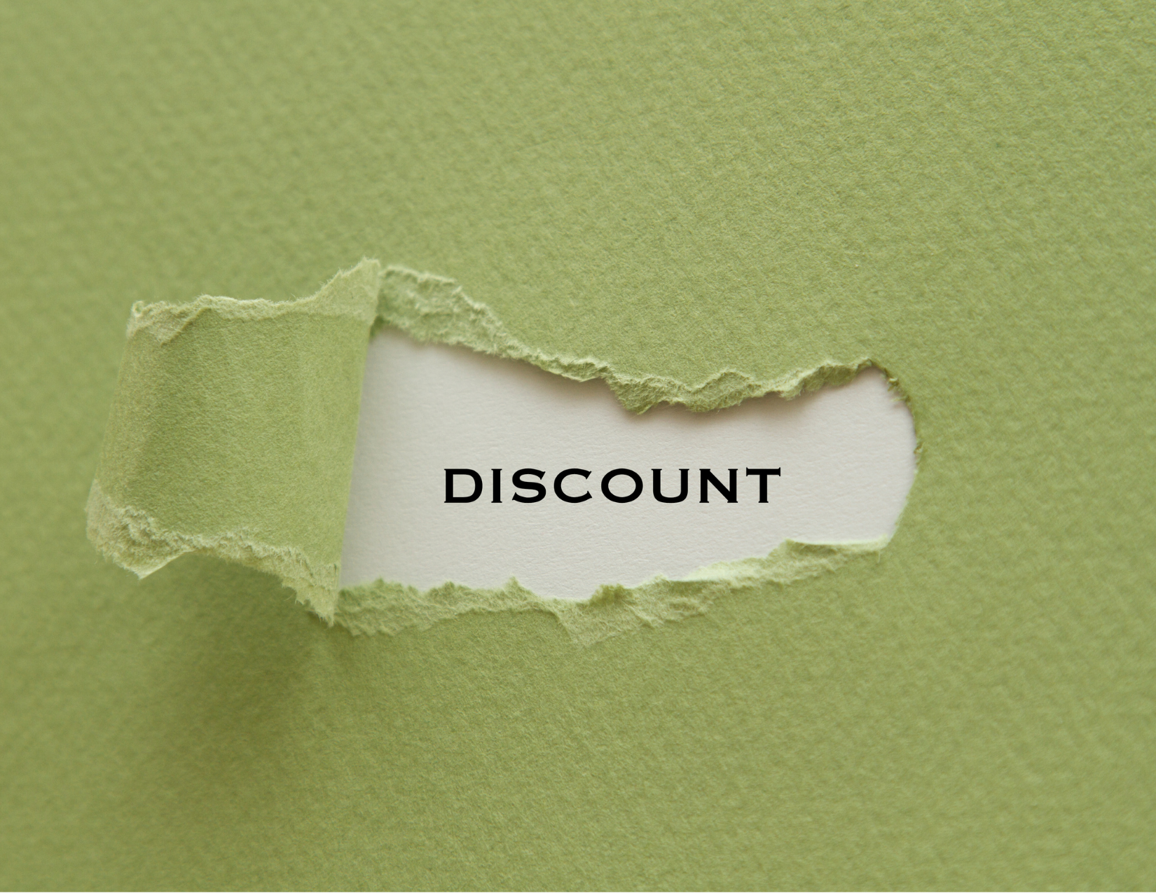 A green paper torn in the middle to reveal the phrase discount on